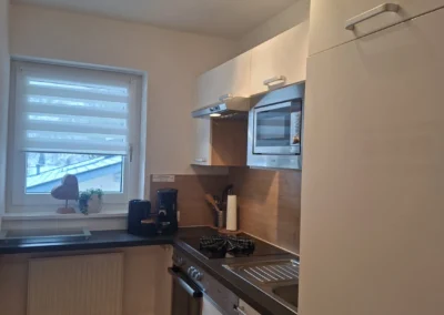 Moderne Kochnische im Appartement Alpenglühn